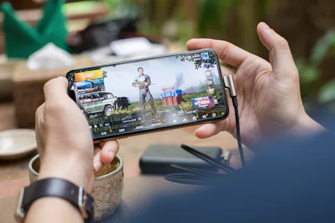 Person holding a smartphone in landscape mode while playing a mobile game